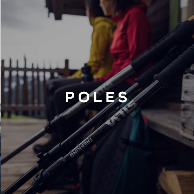 Silva trekking poles leaning against wall with travelers resting behind.